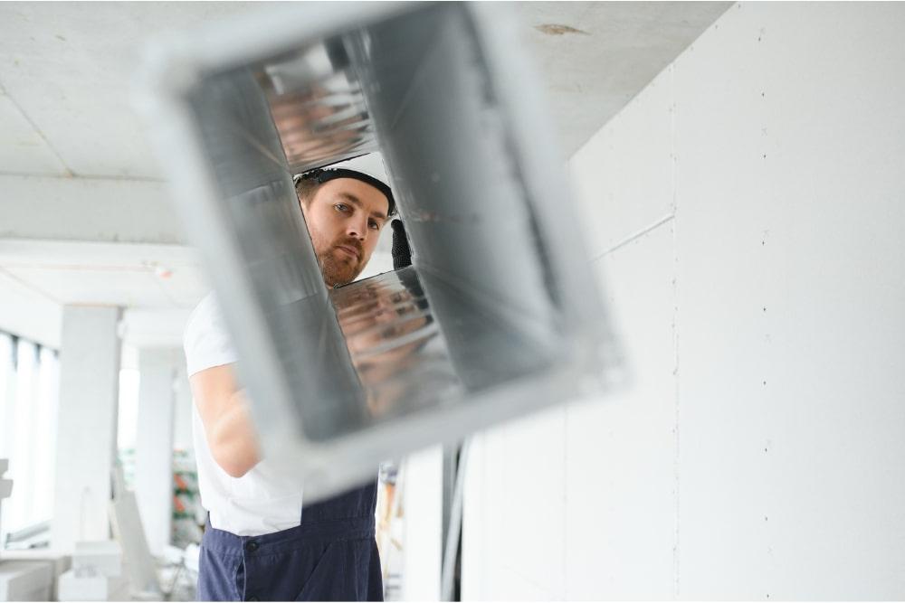 man looking through a vent